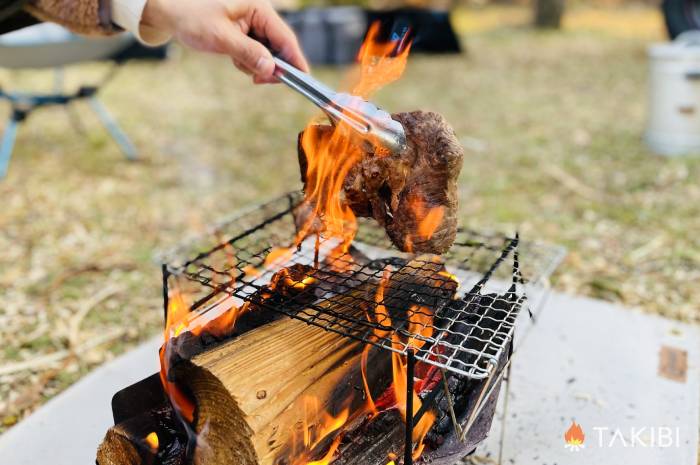 焚き火台で肉を焼くシーン